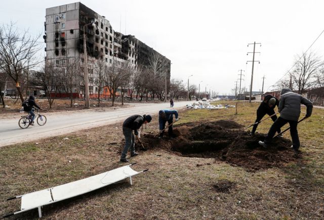 Digging graves on the side of the road in Mariupol, March 20