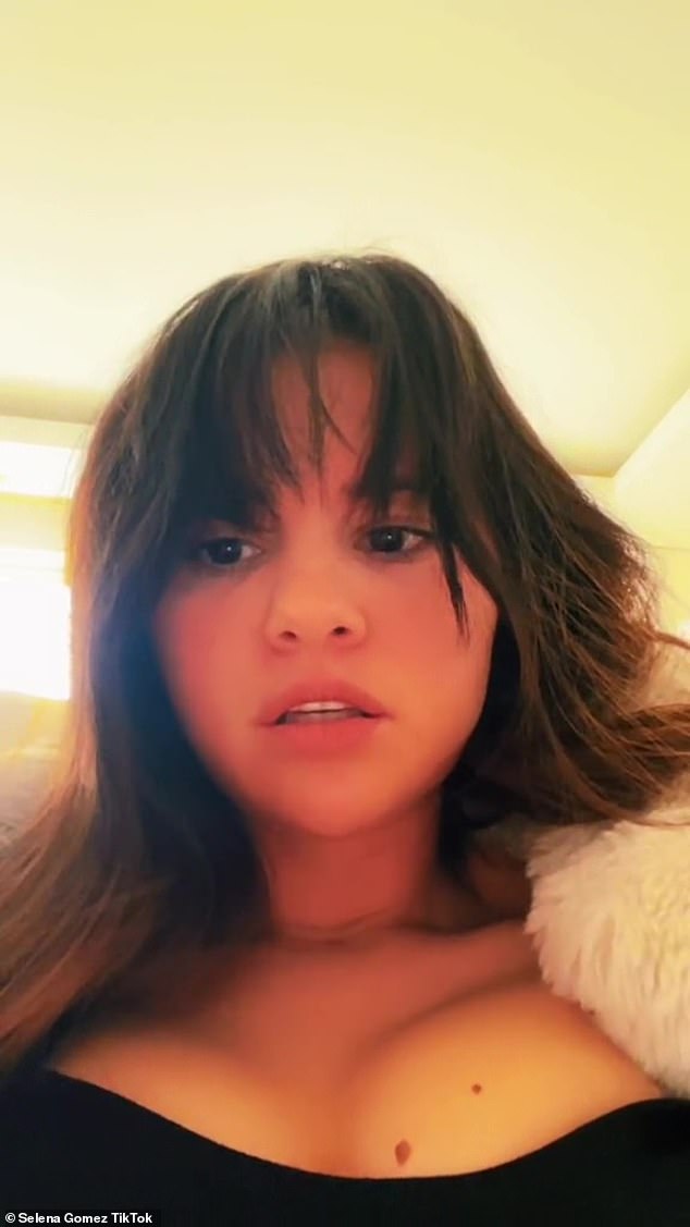 Selena Gomez mocks her love life as she shows her cleavage and her bangs in the video