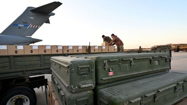 Ukrainian soldiers unload a shipment of US-made weapons